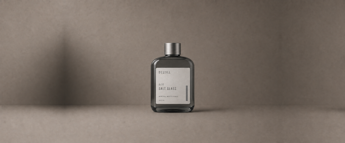 Salt Glass mineral mouth rinse by DESTILL on a warm mineral clay background