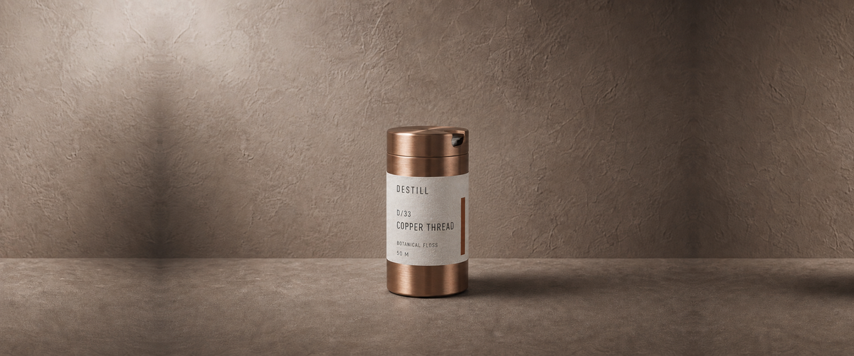 Copper Thread botanical floss by DESTILL on a warm mineral clay background