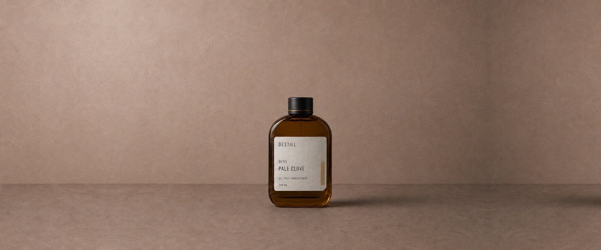 Pale Clove oil pull concentrate by DESTILL on a warm mineral clay background